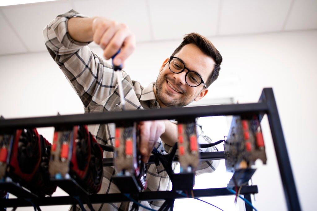 RENTA DE EQUIPOS serviceman checking up bitcoin mining rig.
